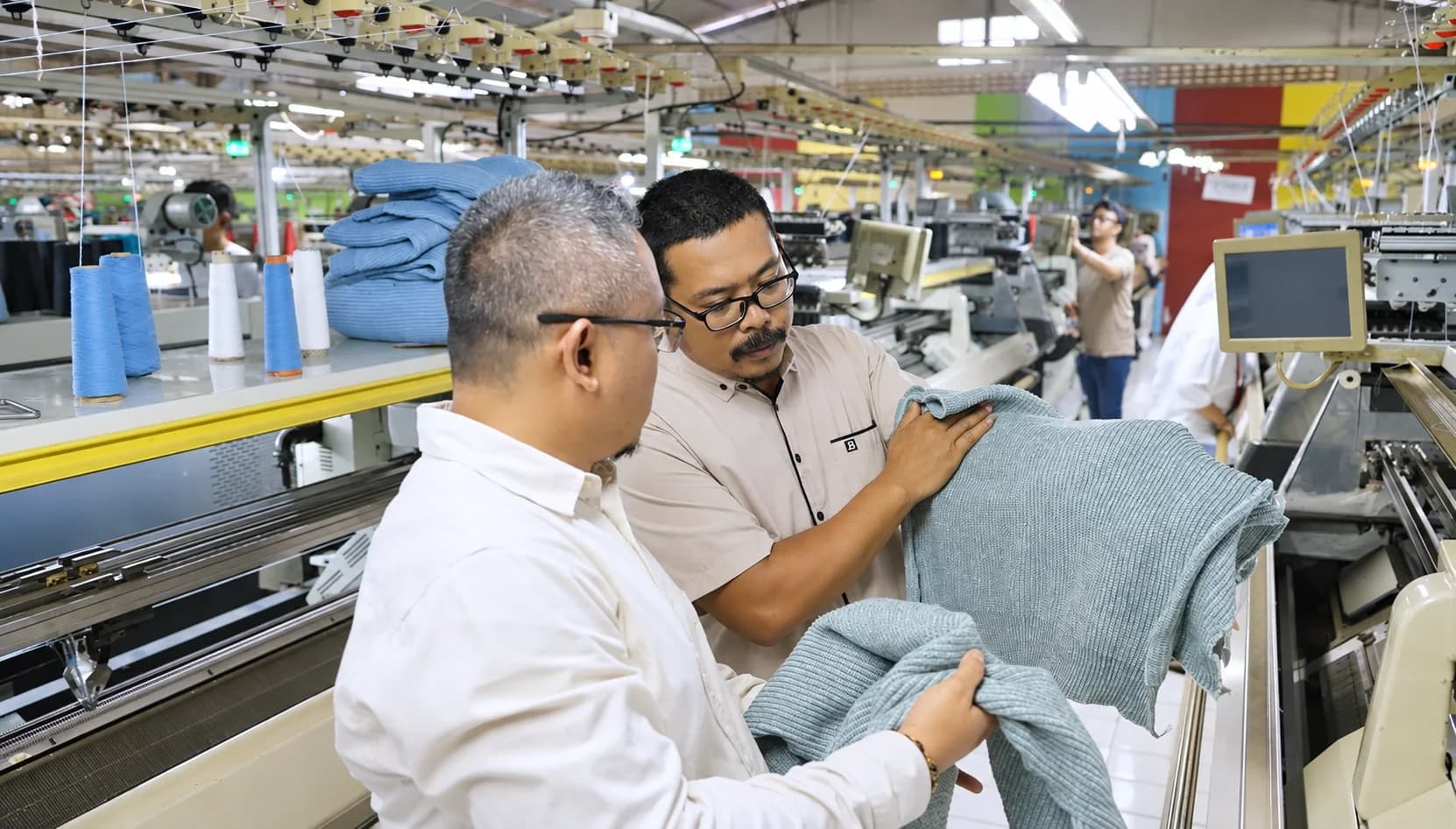 Close-up inspection of knit fibers and fabric weave at the quality control table